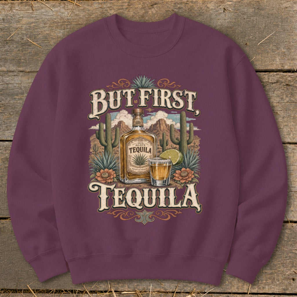 Burgundy sweatshirt with "But First, Tequila" graphic featuring a tequila bottle, shot glass, and desert landscape.