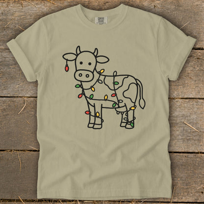 T-shirt with a black line drawing of a cow wrapped in colorful Christmas lights.