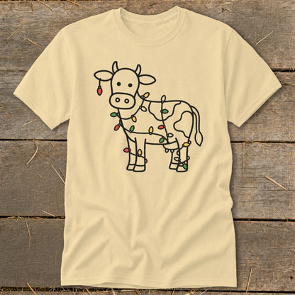 Light yellow t-shirt with a black outline drawing of a cow decorated with colorful Christmas lights.