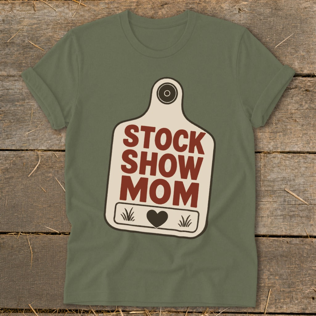 Olive green t-shirt with "STOCK SHOW MOM" text on a tag graphic.