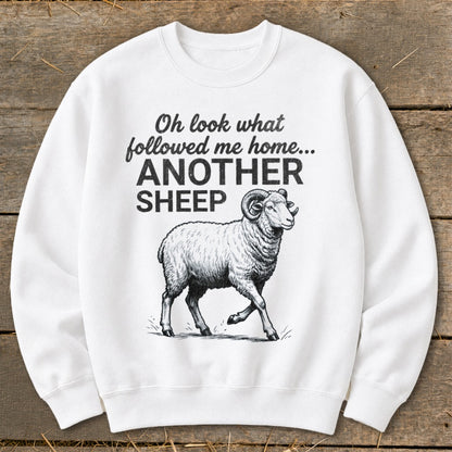 White sweatshirt with black text "Oh look what followed me home... ANOTHER SHEEP" and a drawing of a ram.