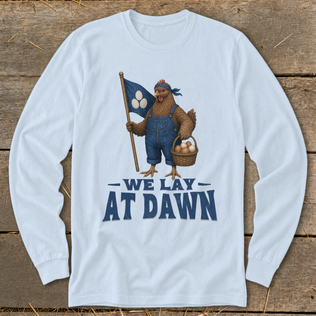 T-shirt graphic of a chicken holding a flag and basket with text "WE LAY AT DAWN".
