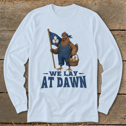 T-shirt graphic of a chicken holding a flag and basket with text "WE LAY AT DAWN".