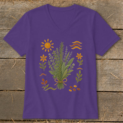 Purple t-shirt with a bouquet of herbs, sun, flowers, and abstract shapes.