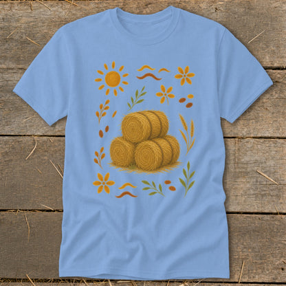 Light blue t-shirt with a pile of hay bales and autumn-themed illustrations.