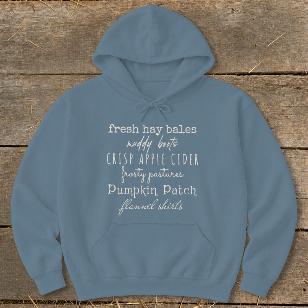 Blue hoodie with text: fresh hay bales, muddy boots, crisp apple cider, frosty pastures, Pumpkin Patch, flannel shirts.