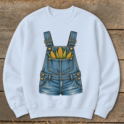 White sweatshirt with a printed graphic of denim overalls holding corn cobs.