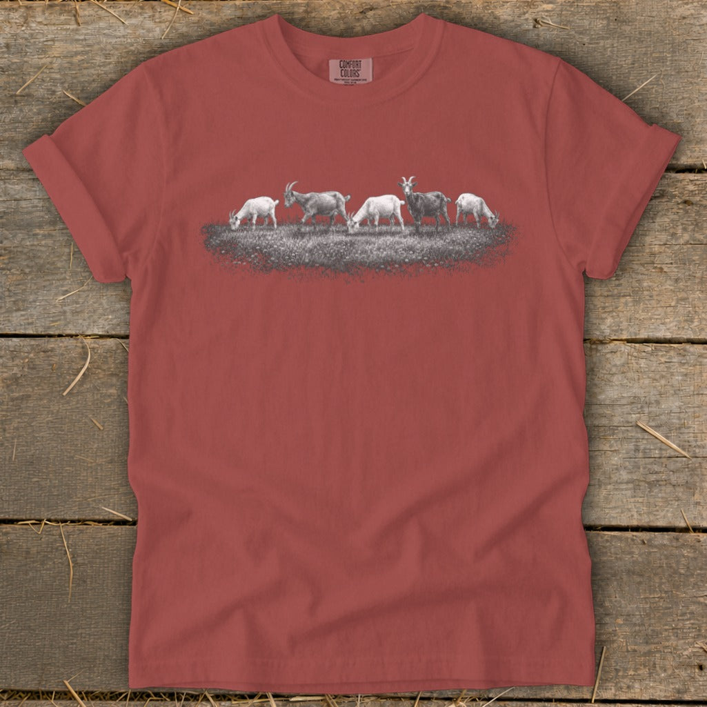 T-shirt with a row of goats grazing on grass.