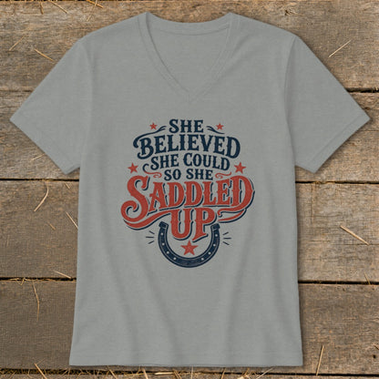 Grey v-neck t-shirt with "She believed she could so she saddled up" graphic.