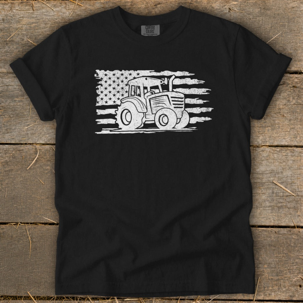 Black t-shirt with white distressed tractor graphic overlaid on American flag design.