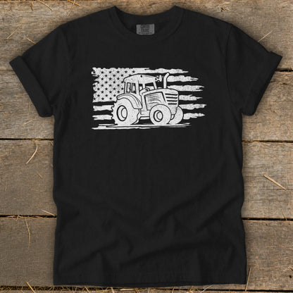 Black t-shirt with white distressed tractor graphic overlaid on American flag design.