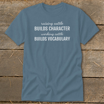 Blue t-shirt with white text: "raising cattle BUILDS CHARACTER working cattle BUILDS VOCABULARY".