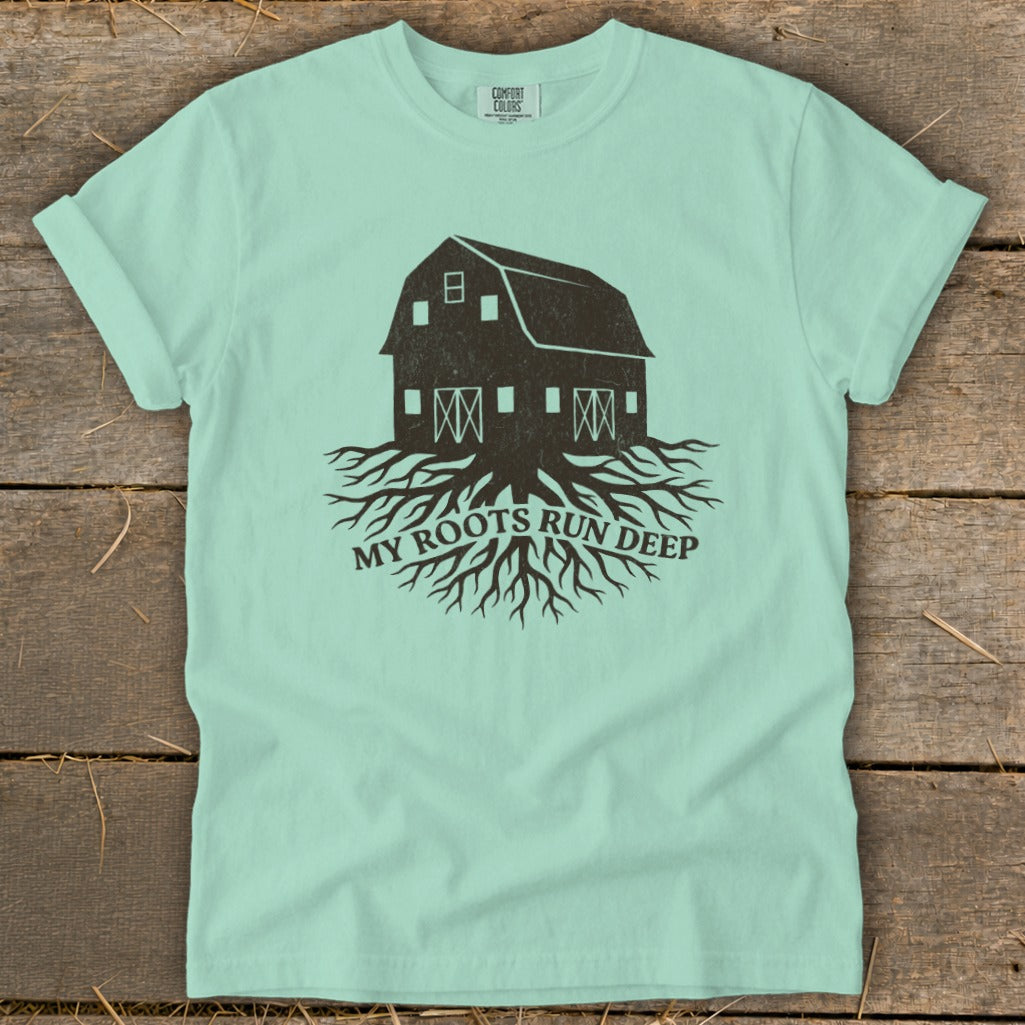 Pale blue t-shirt with a dark brown graphic of a barn on roots, text "MY ROOTS RUN DEEP".