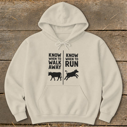 Beige hoodie with text "Know when to walk away" and "Know when to run" and cow graphics.