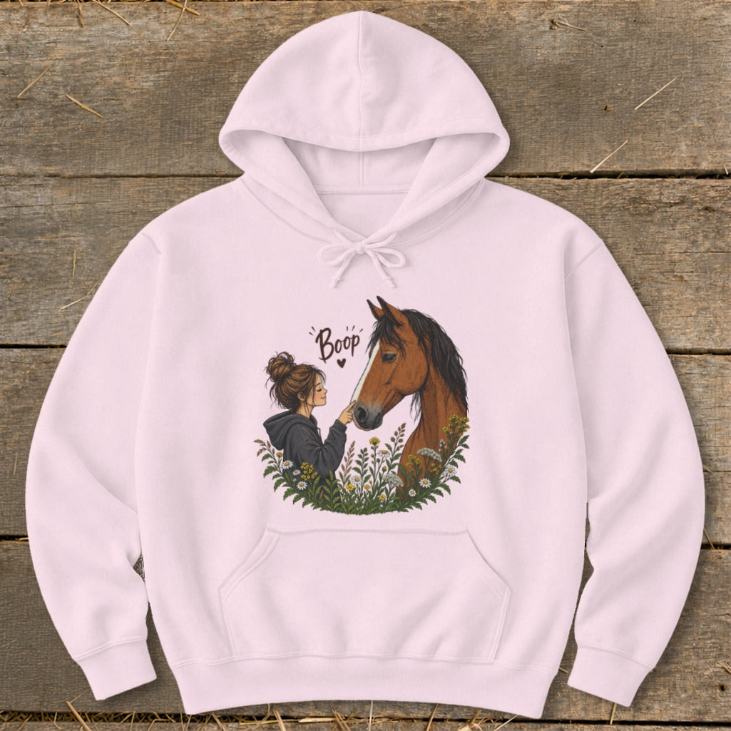 Pink hoodie with illustration of a girl booping a horse's nose surrounded by flowers.