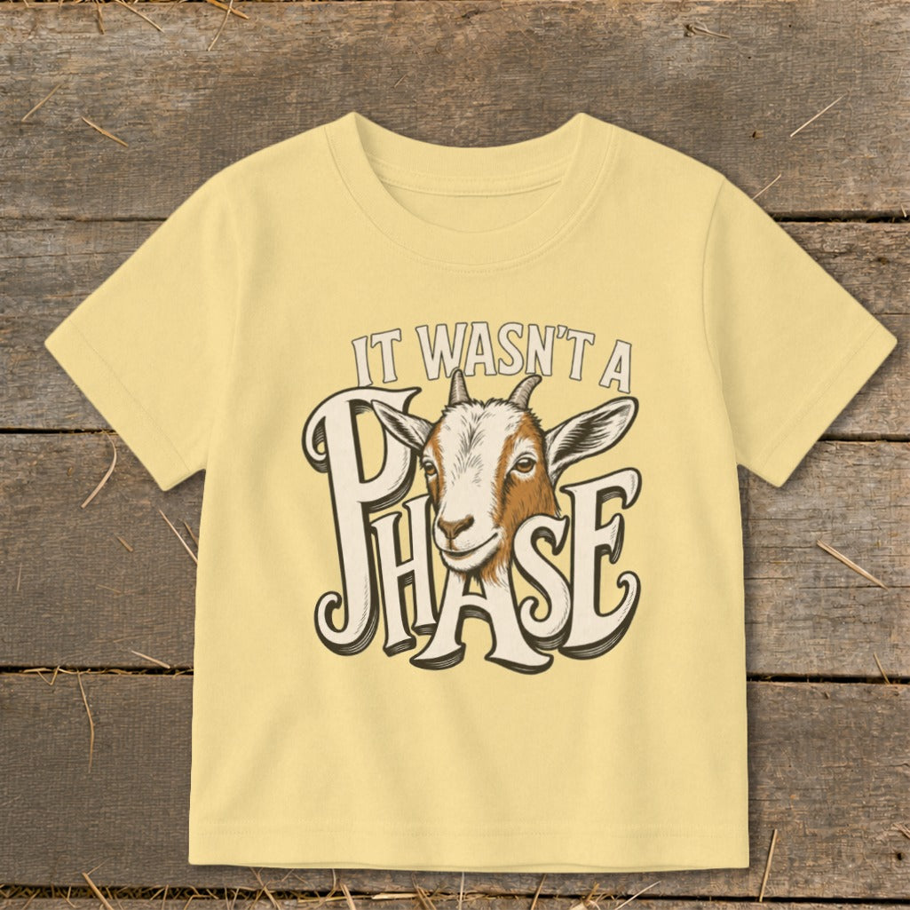 Yellow t-shirt with a goat graphic and the text "IT WASN'T A PHASE".