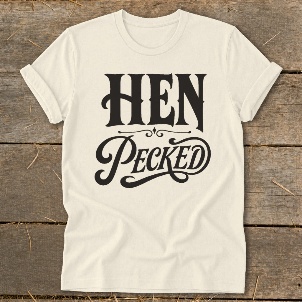 Cream t-shirt with black text reading "HEN PECKED" in a decorative font.