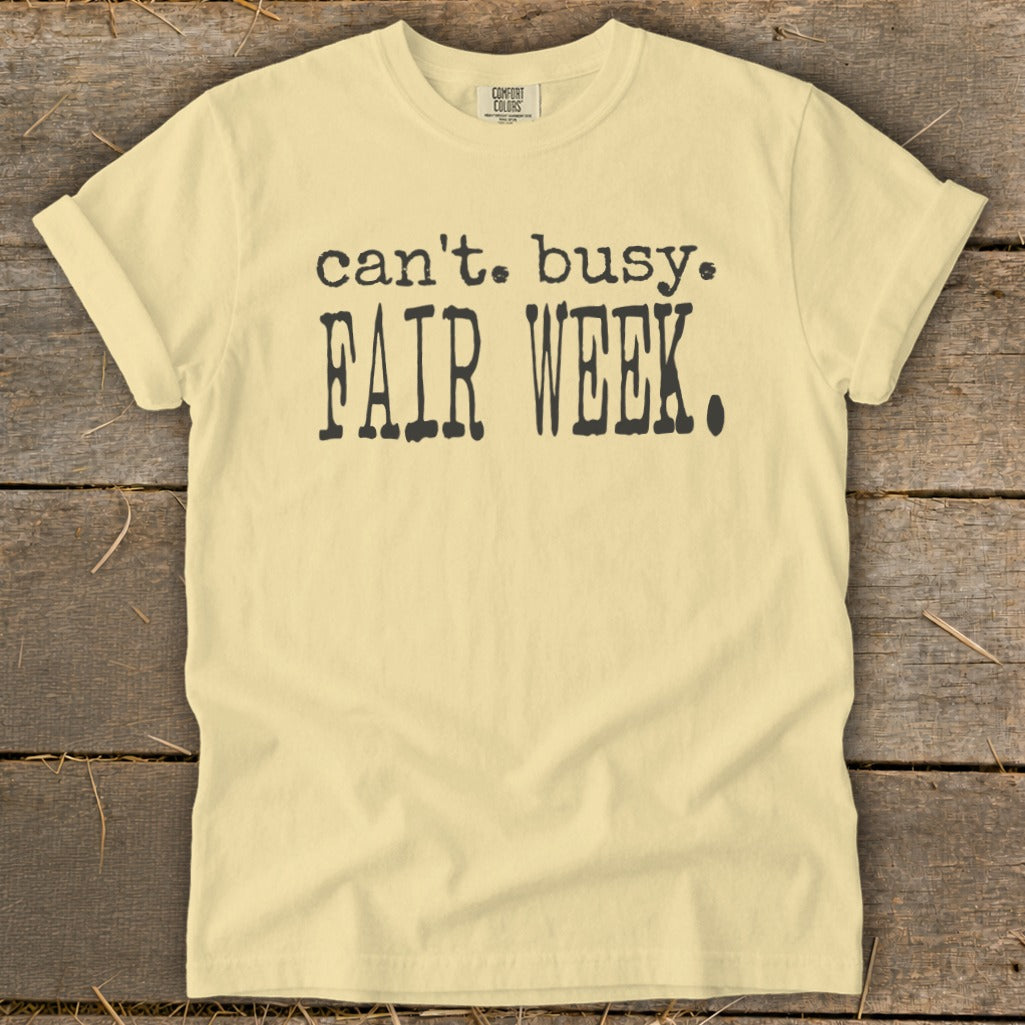 Light yellow t-shirt with black text that says "can't. busy. FAIR WEEK."