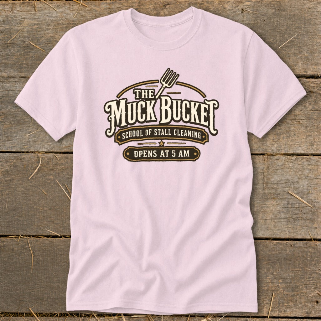 Pink t-shirt with "The Muck Bucket School of Stall Cleaning Opens at 5 AM" graphic.