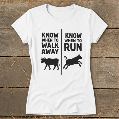 White t-shirt with text "KNOW WHEN TO WALK AWAY" and a walking cow, and "KNOW WHEN TO RUN" with a running cow.
