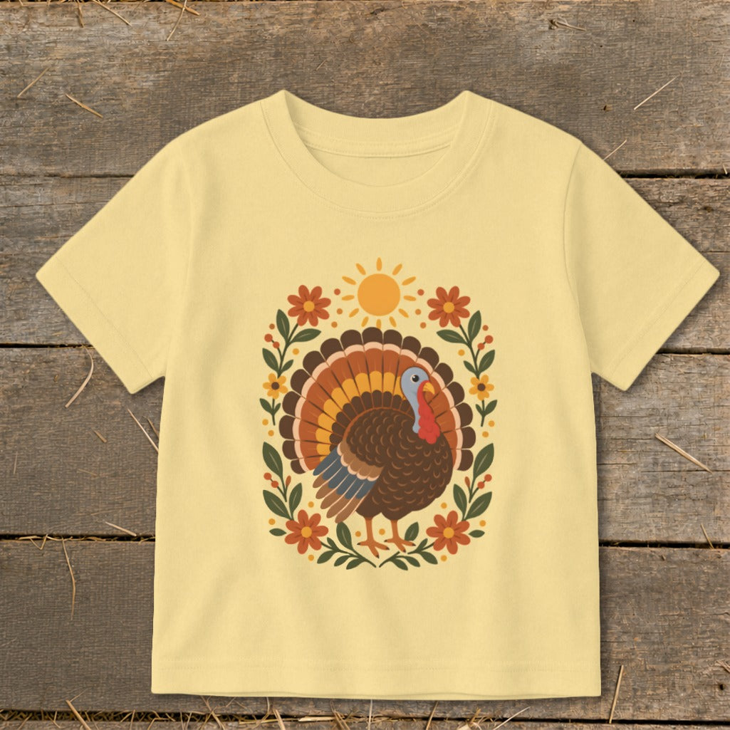 Light yellow t-shirt with a graphic of a turkey and floral wreath.