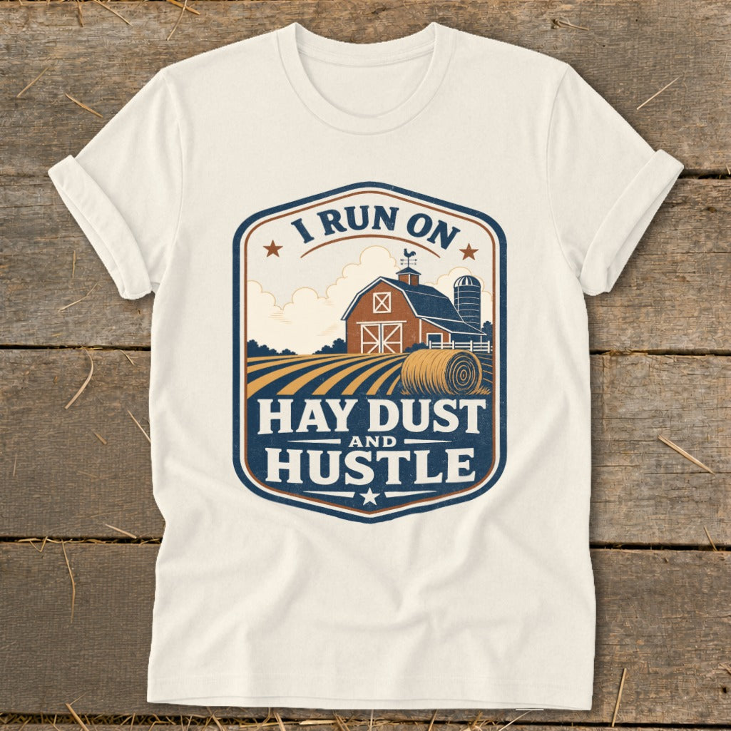 Cream t-shirt with "I Run On Hay Dust And Hustle" farm graphic.