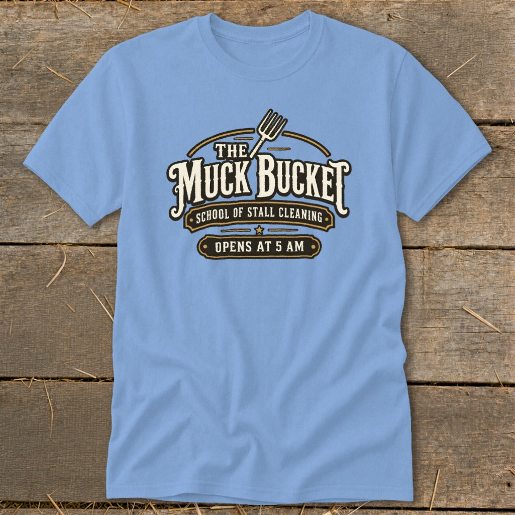 Light blue t-shirt with "The Muck Bucket School of Stall Cleaning Opens At 5 AM" graphic.