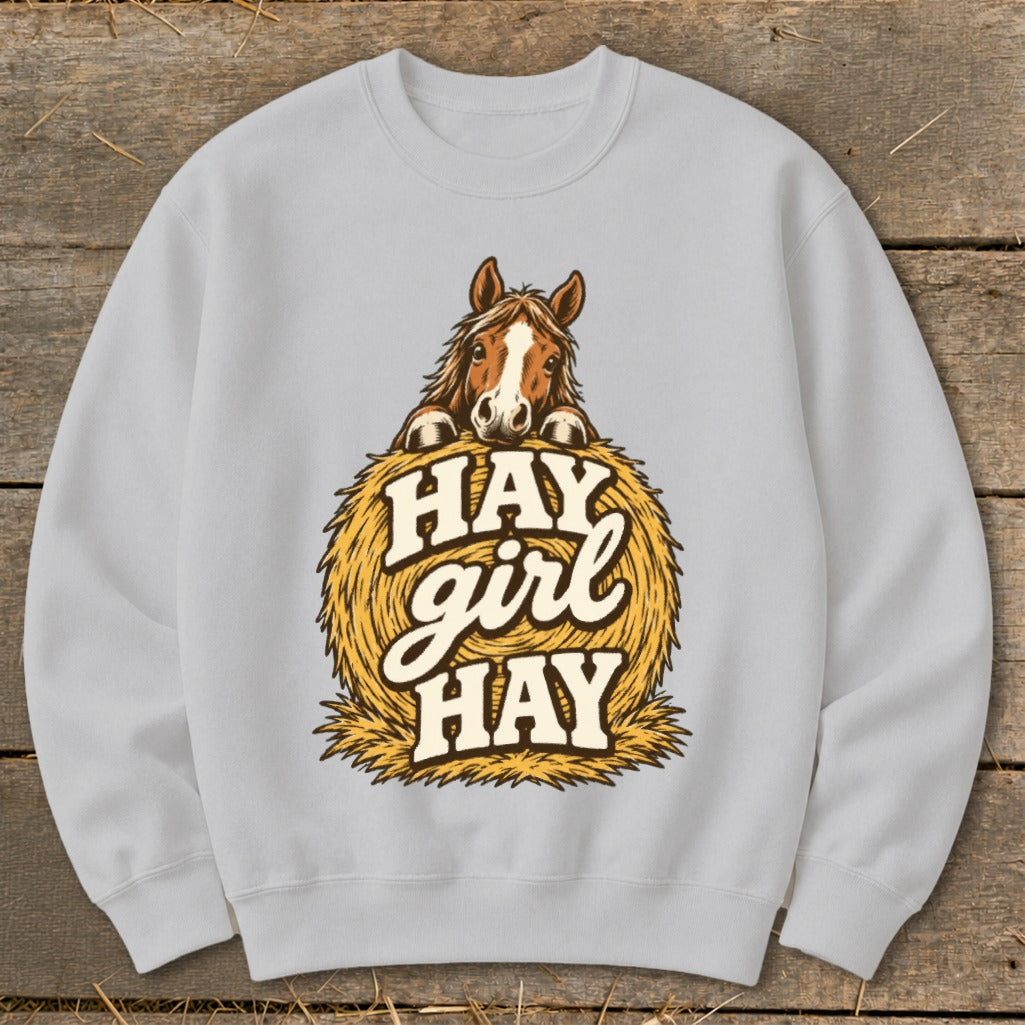 Light grey sweatshirt with a horse peeking over a hay bale with text "Hay Girl Hay".