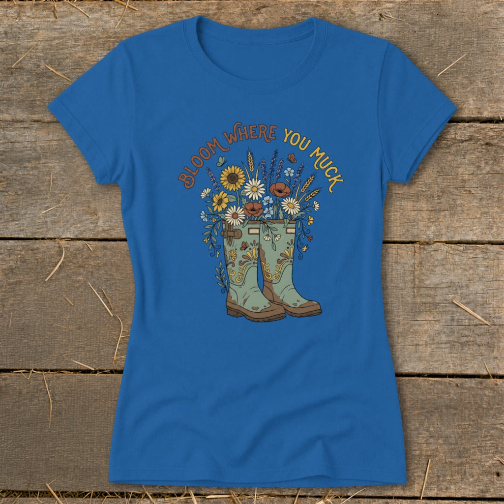 Blue t-shirt with boots and flowers graphic, reading "Bloom Where You Muck."