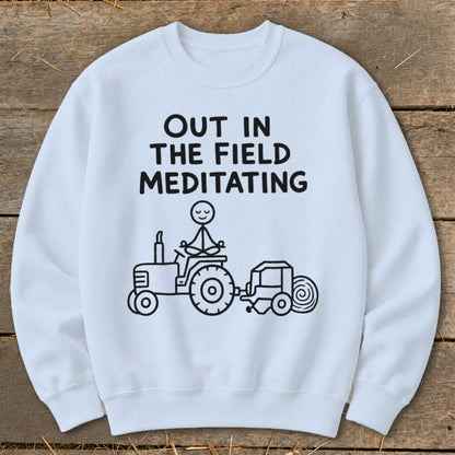 White sweatshirt with black text and illustration of a stick figure meditating on a tractor.