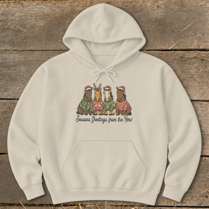 Cream hoodie with four horses wearing Christmas sweaters and hats; text says "Seasons Greetings from the Herd."