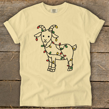 Cream t-shirt with a line drawing of a goat wrapped in colorful Christmas lights.