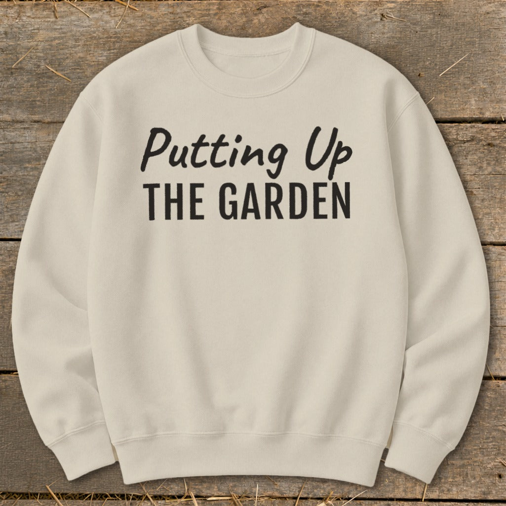 Cream sweatshirt with black text reading "Putting Up THE GARDEN."