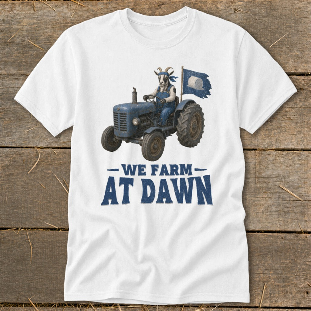 White t-shirt with a goat driving a blue tractor, holding a flag, and text "We Farm At Dawn".
