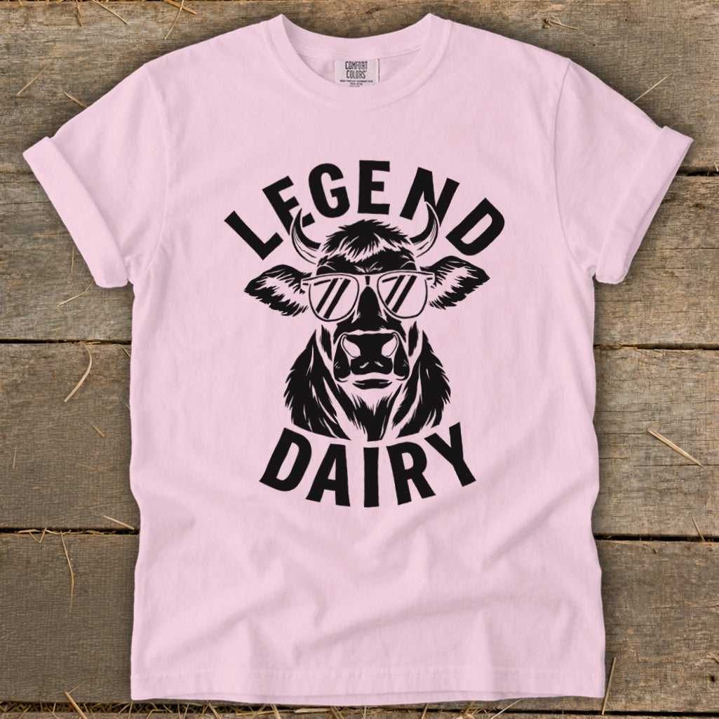 Pink t-shirt with black graphic of cow wearing sunglasses and text "LEGEND DAIRY".