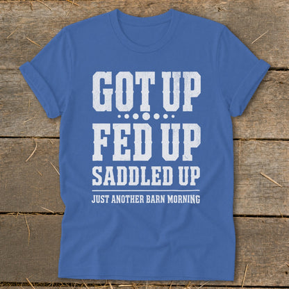 Blue t-shirt with white text reading "GOT UP FED UP SADDLED UP JUST ANOTHER BARN MORNING".