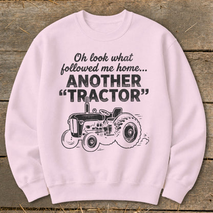 Pink sweatshirt with black graphic of a tractor and text: "Oh look what followed me home... ANOTHER 'TRACTOR'"