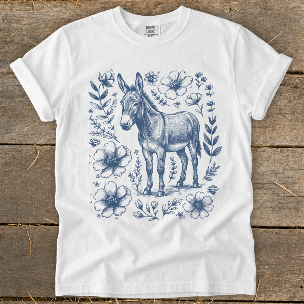 White t-shirt with a blue line drawing of a donkey surrounded by flowers.
