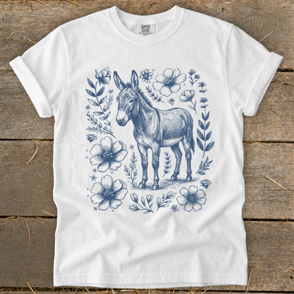 White t-shirt with a blue line drawing of a donkey surrounded by flowers.