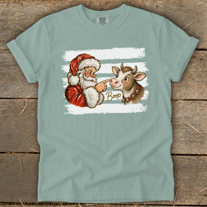 Santa booping a cow with the word "Boop" written on the shirt.