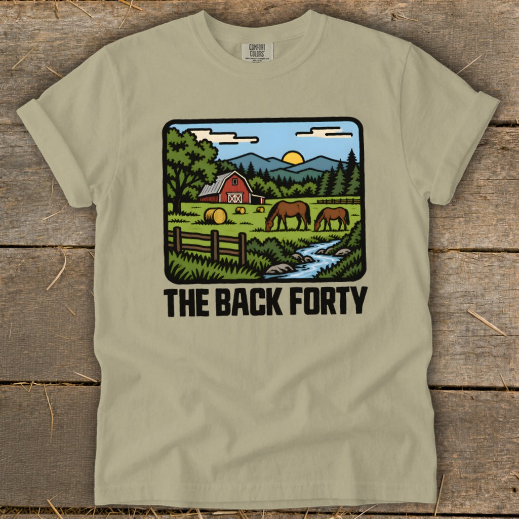 A light green t-shirt with a vintage-style graphic of a farm, horses, and the text The Back Forty.