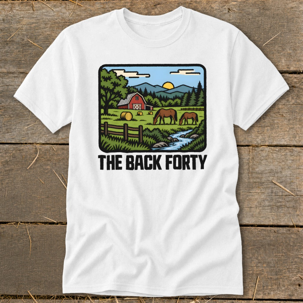 A white t-shirt featuring a cartoon illustration of a red barn, horses, and mountains with the text THE BACK FORTY.
