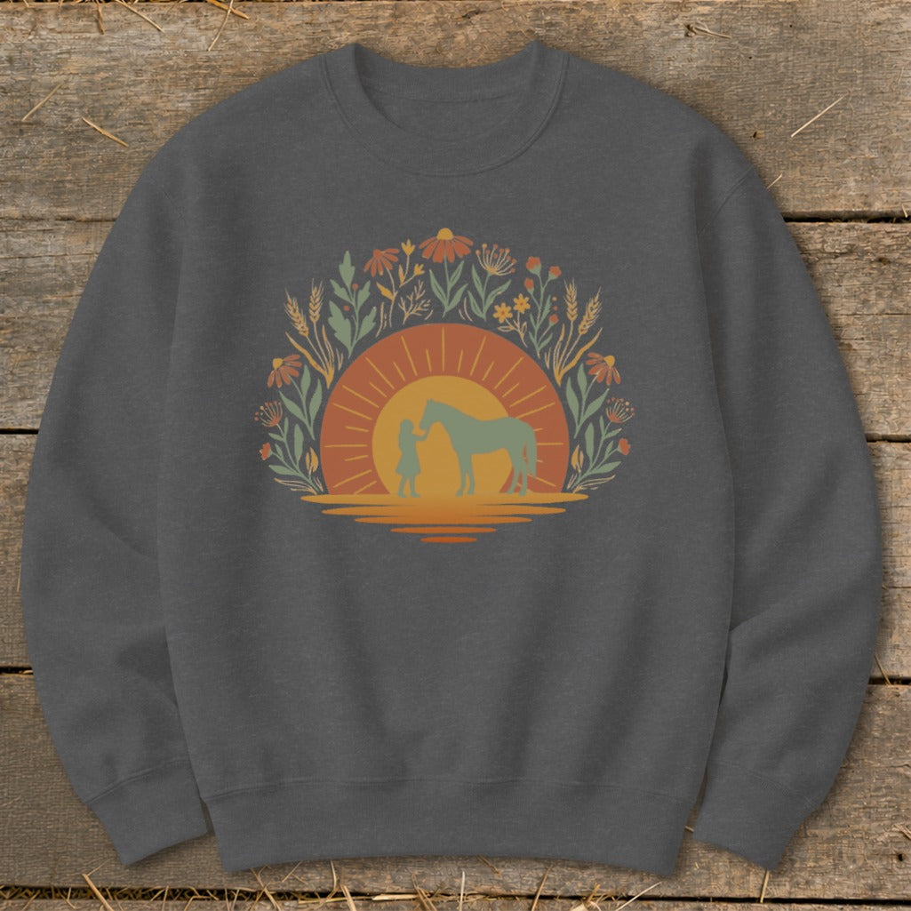 Silhouette of a girl and horse at sunset surrounded by wildflowers and wheat.