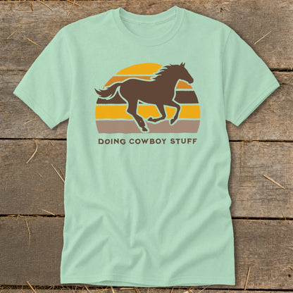 Light green t-shirt with a brown running horse silhouette over a retro sunset.
