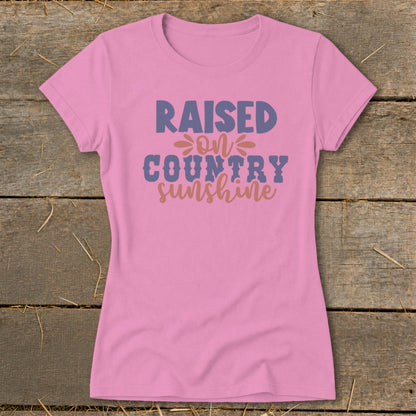 Pink t-shirt with "Raised on Country Sunshine" text graphic.