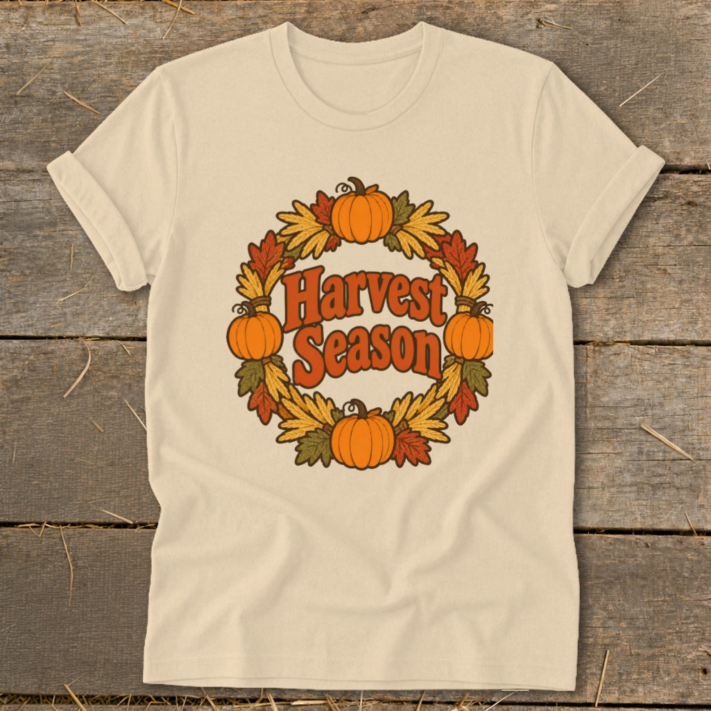 Cream t-shirt with a circular harvest wreath design featuring pumpkins and autumn leaves.
