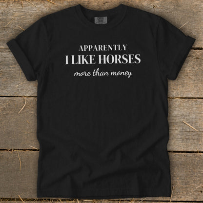 Black t-shirt with white text that says "APPARENTLY I LIKE HORSES more than money".