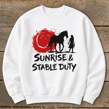 White sweatshirt with black graphic: horse, rider, red sun, and text "SUNRISE & STABLE DUTY".