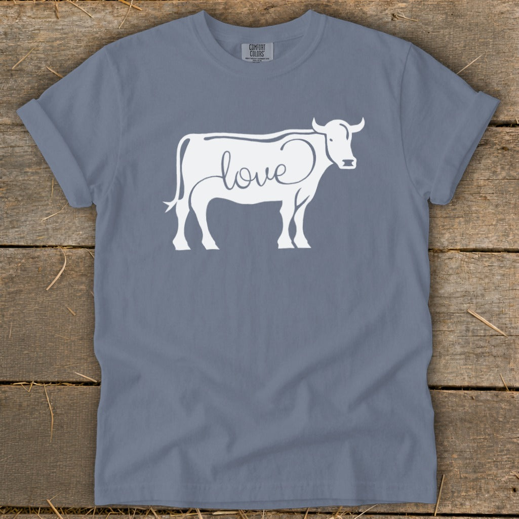 White cow silhouette with "love" text integrated on a slate blue t-shirt.