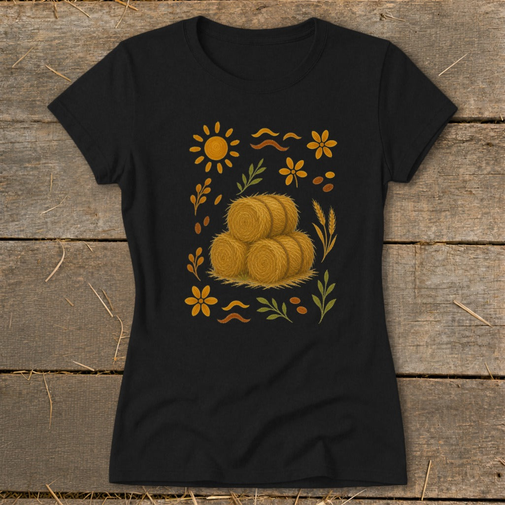 Black t-shirt with a stylized farm harvest graphic featuring hay bales, sun, and flowers.